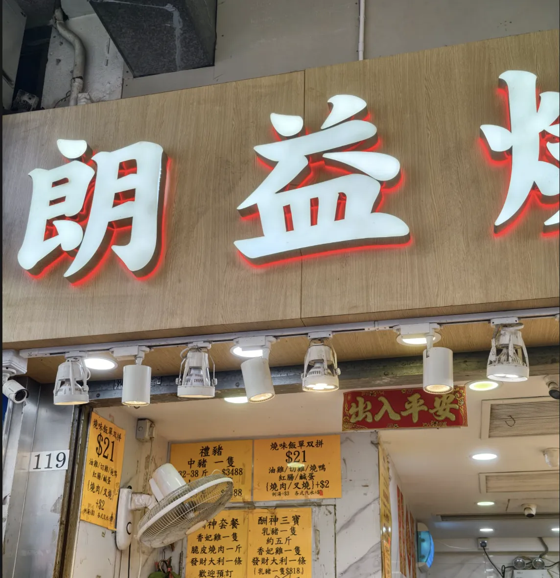 朗益燒味工房門面，木色招牌下方貼有燒味飯價目牌，左側門柱標示119號